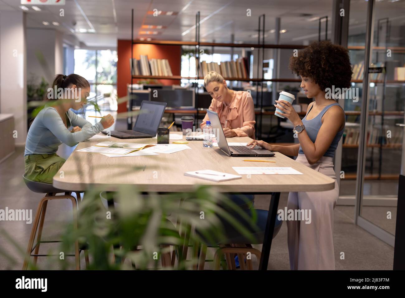 Biracial female advisors working at table in modern workplace Stock Photo