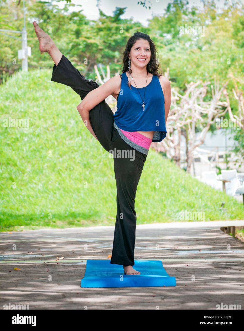 Girl doing yoga bird of paradise, a girl doing yoga outdoors, A woman doing balance yoga, person doing yoga Svarga Dvijasana Stock Photo