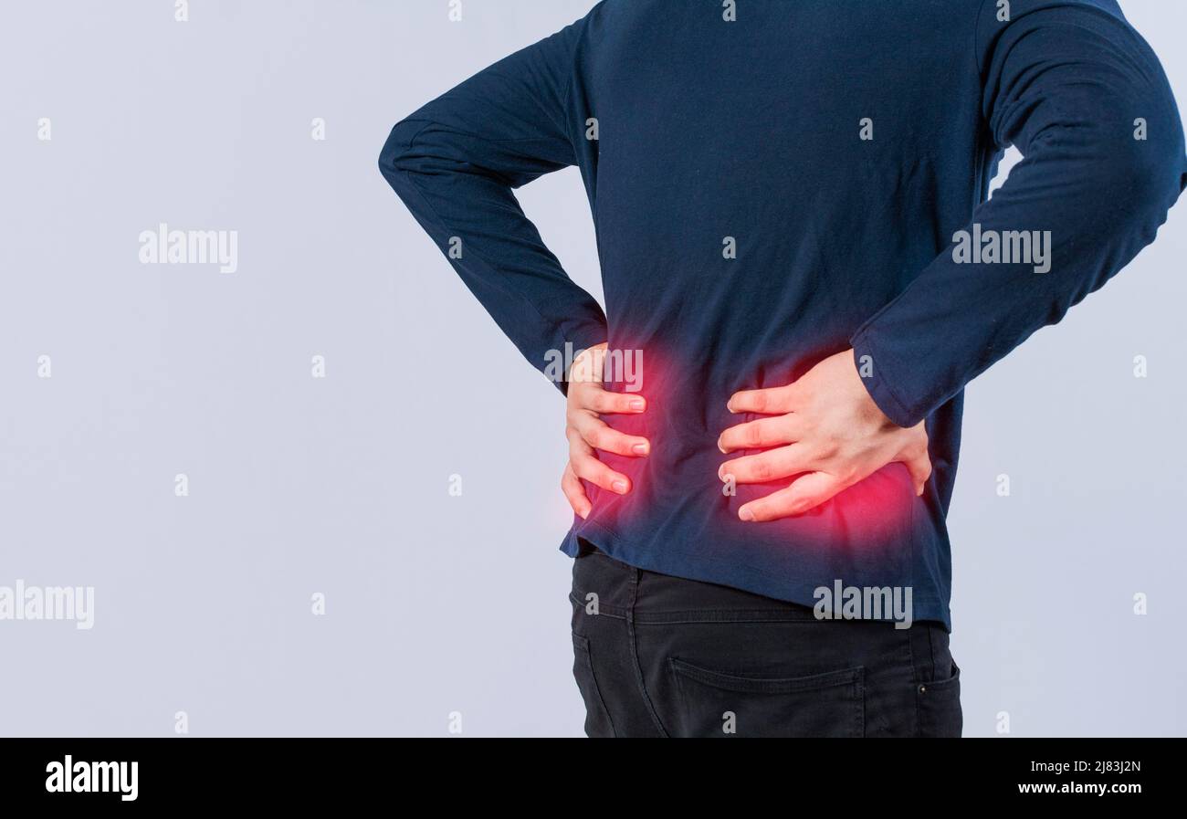 Person with back problems on isolated background, lumbar problems concept, Man with spine problems, a sore man with back pain Stock Photo