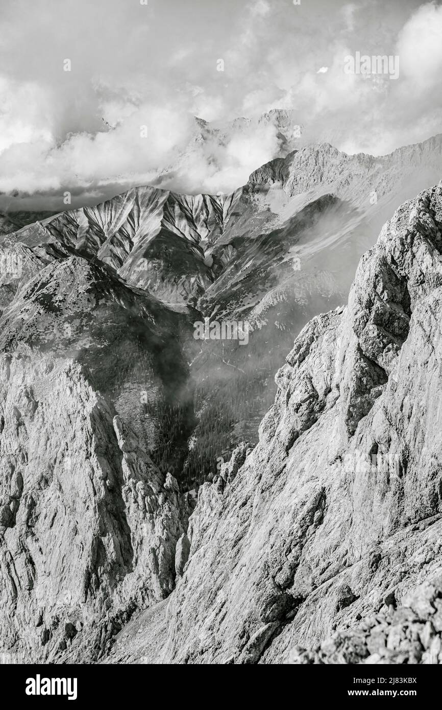 Rocky ridge of Hohe Munde, in the background mountain peaks Hoher Kamm and Kleiner Wanner of the Wetterstein Mountains, black and white photo, view Stock Photo