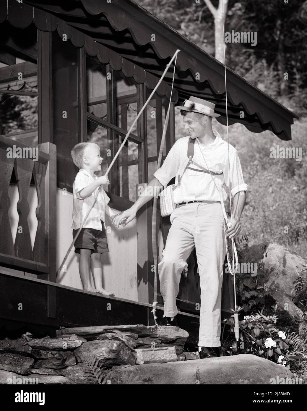 1950s LITTLE BAREFOOT BOY WITH FISHING POLE HOLDING HANDS WITH DAD WITH FISHING  GEAR TO GO FLY FISHING IN FRONT OF CABIN - j1610 HAR001 HARS OLD TIME STICK  NOSTALGIA GEAR OLD