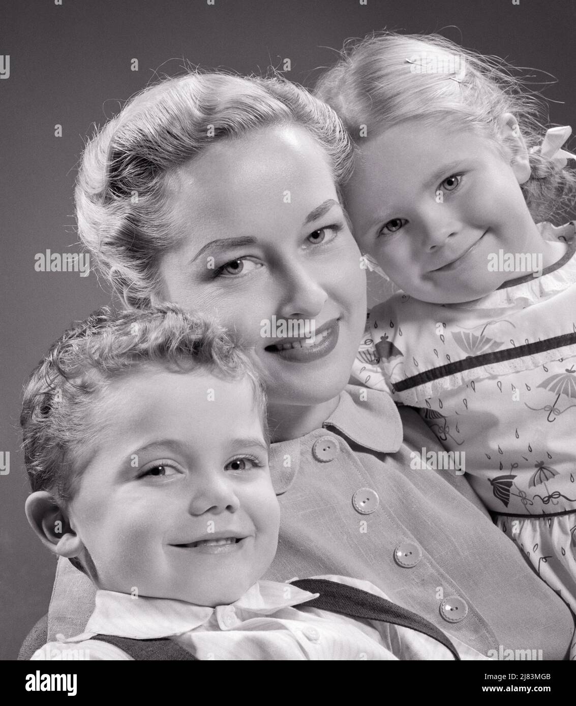 1950s SMILING PORTRAIT OF BLONDE MOTHER WITH TWO CHILDREN A BOY AND A GIRL ALL LOOKING AT CAMERA - j2719 HAR001 HARS OLD TIME NOSTALGIA OLD FASHION SISTER 1 JUVENILE STYLE YOUNG ADULT STRONG SONS PLEASED FAMILIES JOY LIFESTYLE SATISFACTION FEMALES STUDIO SHOT HEALTHINESS HOME LIFE COPY SPACE FRIENDSHIP HALF-LENGTH LADIES DAUGHTERS PERSONS CARING MALES SISTERS B&W EYE CONTACT HAPPINESS CHEERFUL PROTECTION AND PRIDE SMILES CONNECTION JOYFUL STYLISH PERSONAL ATTACHMENT AFFECTION COOPERATION EMOTION GROWTH MOMS TOGETHERNESS YOUNG ADULT WOMAN BLACK AND WHITE CAUCASIAN ETHNICITY HAR001 OLD FASHIONED Stock Photo
