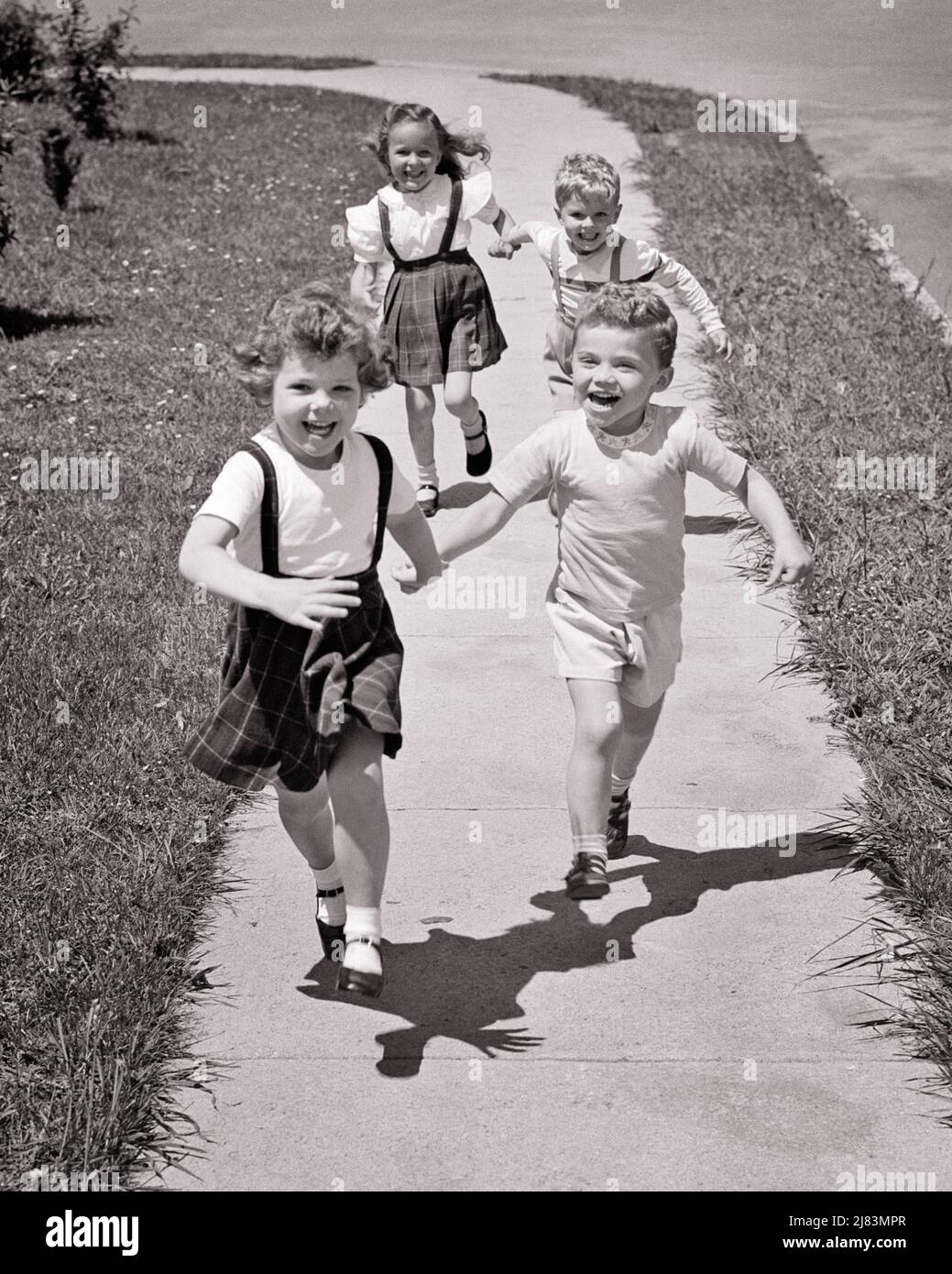 https://c8.alamy.com/comp/2J83MPR/1950s-four-kids-running-on-suburban-sidewalk-towards-looking-at-camera-two-boy-and-girl-couples-holding-hands-smiling-laughing-j3967-har001-hars-brother-old-fashion-sister-fitness-juvenile-facial-laugh-healthy-friend-teamwork-competition-pleased-joy-lifestyle-speed-females-brothers-healthiness-friendship-full-length-physical-fitness-persons-males-siblings-towards-confidence-sisters-expressions-bw-eye-contact-freedom-activity-happiness-physical-wellness-cheerful-strength-and-excitement-recreation-pride-holding-hands-on-sibling-smiles-conceptual-flexibility-friendly-joyful-muscles-stylish-2J83MPR.jpg