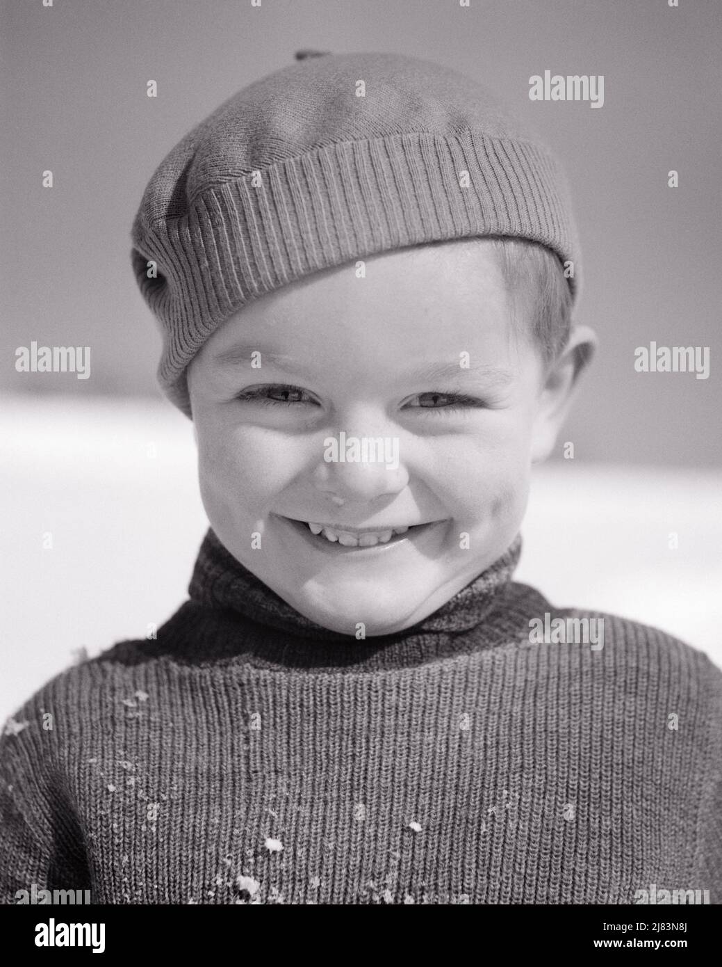 1930s PORTRAIT SMILING LITTLE BOY WEARING KNIT CAP AND TURTLENECK SWEATER DUSTED WITH SNOW FLAKES SQUINTING LOOKING AT CAMERA - j6749 HAR001 HARS HEALTHINESS HOME LIFE COPY SPACE MALES CONFIDENCE EXPRESSIONS B&W KNIT WINTERTIME EYE CONTACT HAPPINESS PERSONALITY HEAD AND SHOULDERS CHEERFUL AND EXCITEMENT KNOWLEDGE SQUINTING HANDSOME PRIDE DIMPLES SMILES FRIENDLY JOYFUL STYLISH PLEASANT WINTERY AGREEABLE CHARMING DUSTED FLAKES GROWTH JUVENILES LOVABLE PERSONABLE PLEASING ADORABLE APPEALING BLACK AND WHITE CAUCASIAN ETHNICITY HAR001 OLD FASHIONED TURTLENECK Stock Photo