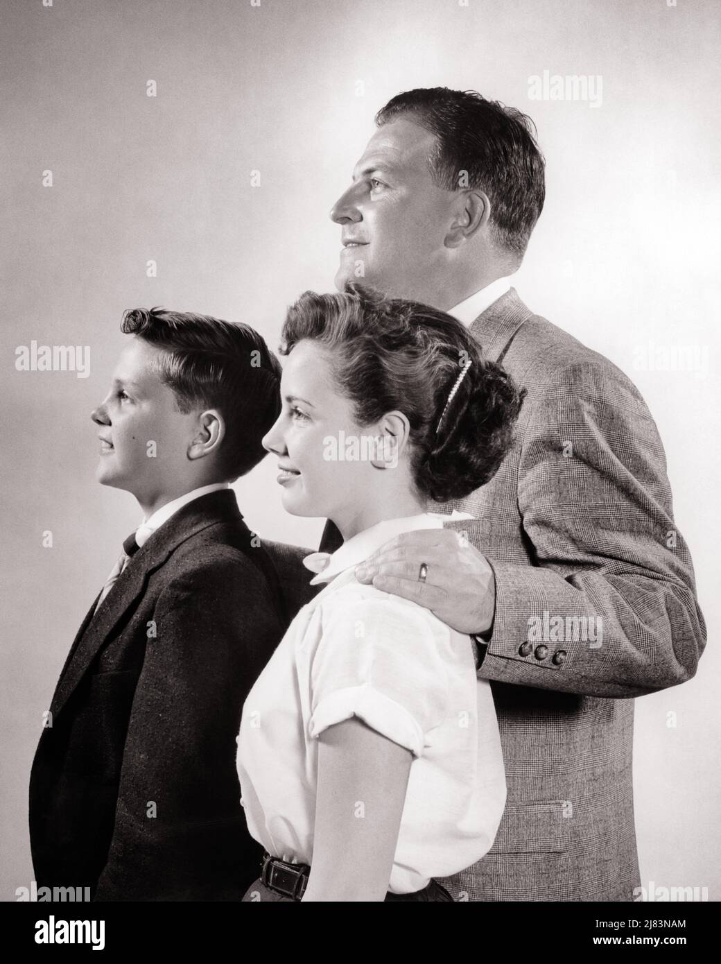 1950s PROFILE PORTRAIT OF FATHER WITH TWO TEEN CHILDREN FATHER IS STANDING BEHIND HIS SON AND DAUGHTER - j7393 HAR001 HARS NOSTALGIA BROTHER OLD FASHION SISTER 1 JUVENILE SECURITY STRONG SONS PLEASED FAMILIES JOY LIFESTYLE FEMALES BROTHERS STUDIO SHOT HOME LIFE COPY SPACE FRIENDSHIP HALF-LENGTH DAUGHTERS PERSONS INSPIRATION CARING MALES TEENAGE GIRL SIBLINGS SPIRITUALITY CONFIDENCE SISTERS FATHERS B&W HAPPINESS CHEERFUL DISCOVERY PROTECTION DADS PRIDE SIBLING SMILES CONNECTION PROFILES CONCEPTUAL JOYFUL SUPPORT TEENAGED PERSONAL ATTACHMENT AFFECTION EMOTION GROWTH JUVENILES MID-ADULT Stock Photo
