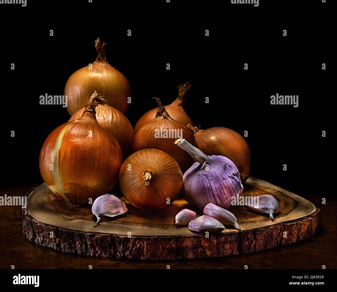 Onion and garlic on a wooden stand. Onion and garlic dishes help to effectively eliminate bacteria, fungi and viruses, preventing many infectious. Stock Photo