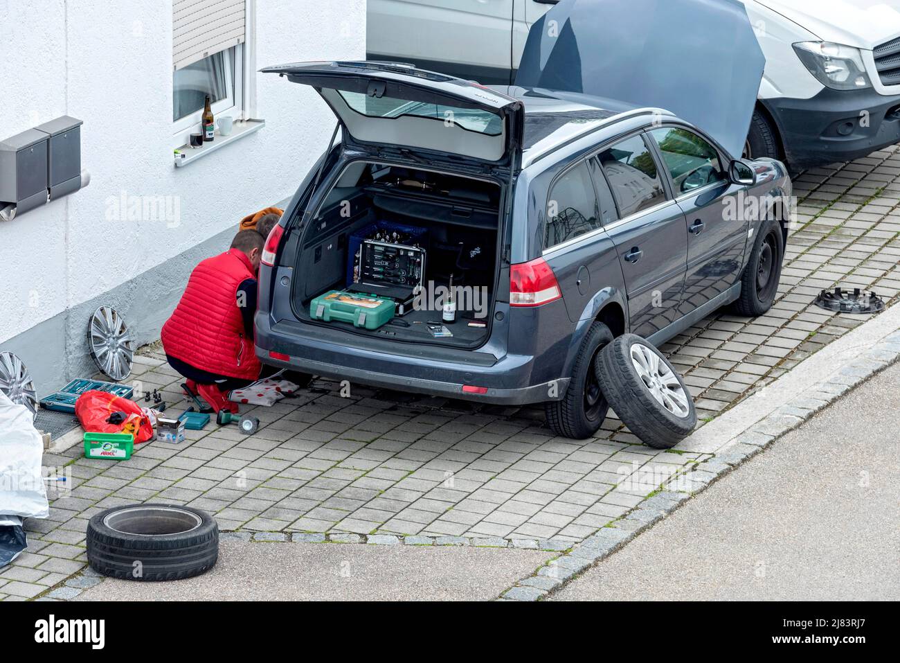 Changing tyres for the season, changing winter to summer, men changing