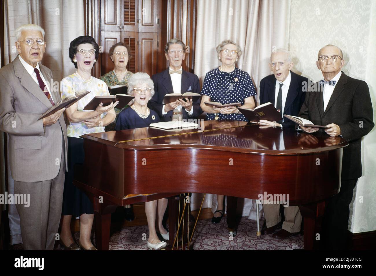 1960s GROUP OF 8 SENIOR CITIZENS MEN AND WOMEN STANDING AROUND PIANO HOLDING HYMNALS SINGING - km1278 HAR001 HARS RELIGION ELDER FEMALES HOME LIFE COPY SPACE FRIENDSHIP HALF-LENGTH LADIES PERSONS INSPIRATION MALES RETIREMENT ENTERTAINMENT SPIRITUALITY CONFIDENCE SENIOR MAN SENIOR ADULT EYE CONTACT SENIOR WOMAN RETIREE ACTIVITY 8 OLD AGE OLDSTERS OLDSTER LEISURE AND AGING RECREATION SONG VOCAL PRIDE OPPORTUNITY ENTERTAINER HOMES ELDERS MUSICAL INSTRUMENT CONNECTION VOCALIZE VOCALS RESIDENCE SENIOR CITIZENS SONGS ELDERLY MAN ASSISTED LIVING COOPERATION ELDERLY WOMAN TOGETHERNESS Stock Photo