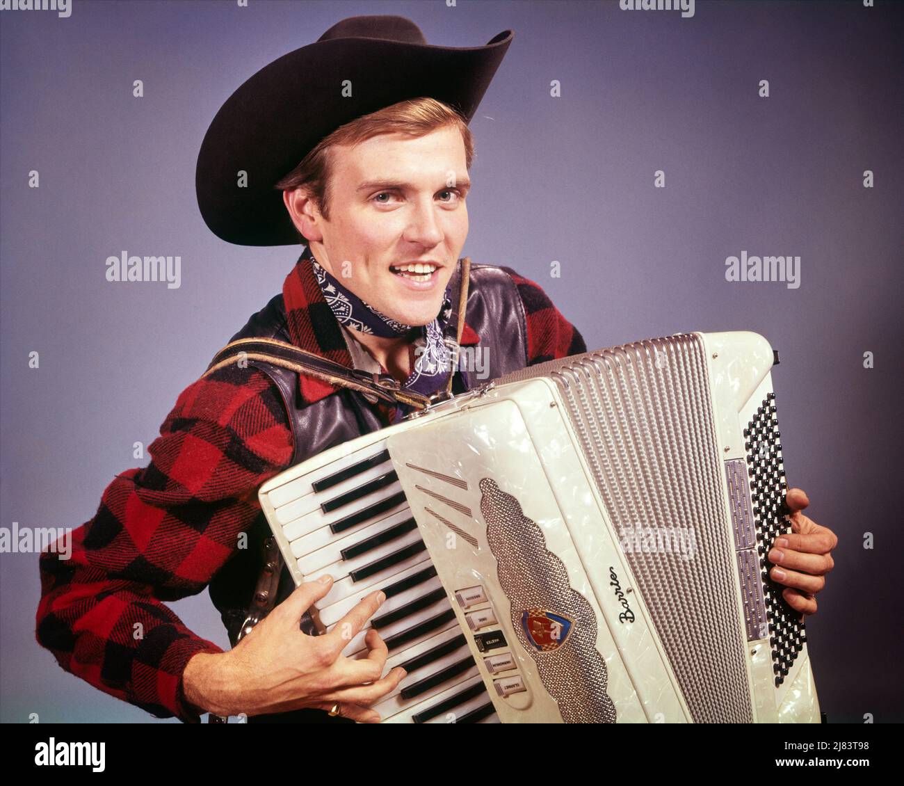 1960s SMILING MAN WEARING COWBOY HAT PLAYING COUNTRY WESTERN MUSIC ON AN ACCORDION LOOKING AT CAMERA - km1279 HAR001 HARS SINGER YOUNG ADULT SINGERS PLEASED JOY LIFESTYLE SOUND SATISFACTION ACTOR MUSICIAN STUDIO SHOT RURAL HEALTHINESS WOOL COPY SPACE FRIENDSHIP HALF-LENGTH PERSONS CHARACTER MALES WESTERN PLAID PROFESSION ENTERTAINMENT CONFIDENCE AMERICANA EXPRESSIONS EYE CONTACT COWBOYS PERFORMING ARTS OCCUPATION HAPPINESS ACCORDION HEAD AND SHOULDERS CHEERFUL PERFORMER AND CAREERS EXCITEMENT SONG VOCAL PRIDE ENTERTAINER OCCUPATIONS SMILES MUSICAL INSTRUMENT VOCALIZE CONCEPTUAL VOCALS ACTORS Stock Photo