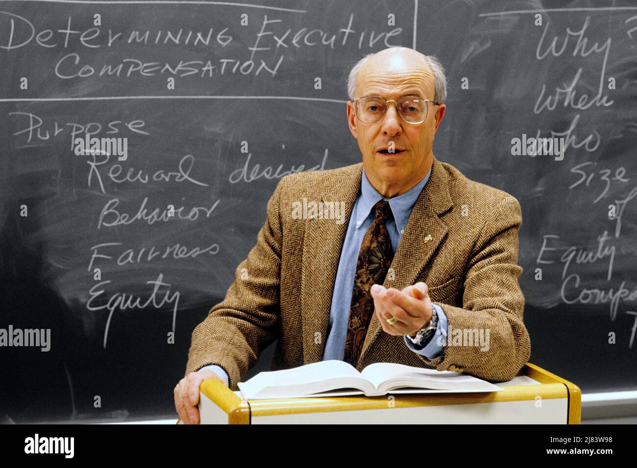 1990s GESTURING ECONOMICS PROFESSOR LECTURING IN CLASSROOM WITH RELEVANT NOTES ON BLACKBOARD CAMDEN NEW JERSEY USA  - ks36314 NET002 HARS OLD FASHION 1 STYLE TEACHERS COMMUNICATION EAST CENTER INFORMATION LIFESTYLE PODIUM TWEED GROWNUP UNITED STATES COPY SPACE HALF-LENGTH PERSONS INSPIRATION MALES ECONOMICS EYEGLASSES GESTURING MIDDLE-AGED NORTH AMERICA MIDDLE-AGED MAN NORTH AMERICAN PROFESSOR SCHOOLS SUIT AND TIE URBAN CENTER UNIVERSITIES INSTRUCTOR KNOWLEDGE LEADERSHIP NORTHEAST TRAVEL USA AUTHORITY GESTURES NJ OCCUPATIONS REGION CAMDEN HIGHER EDUCATION MID-ATLANTIC MID-ATLANTIC REGION Stock Photo