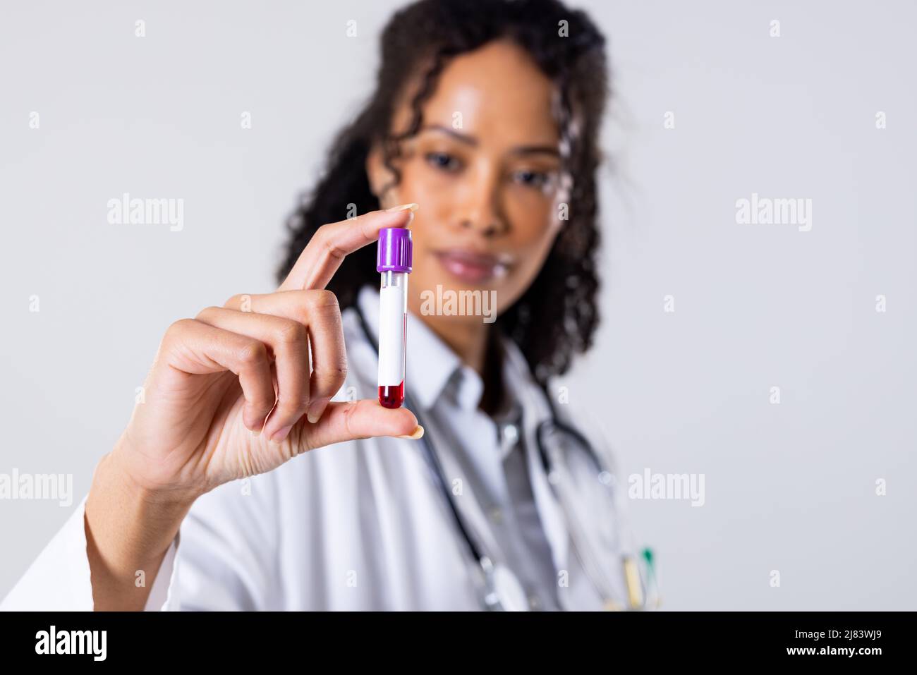 African american mid adult female doctor holding blood sample in test