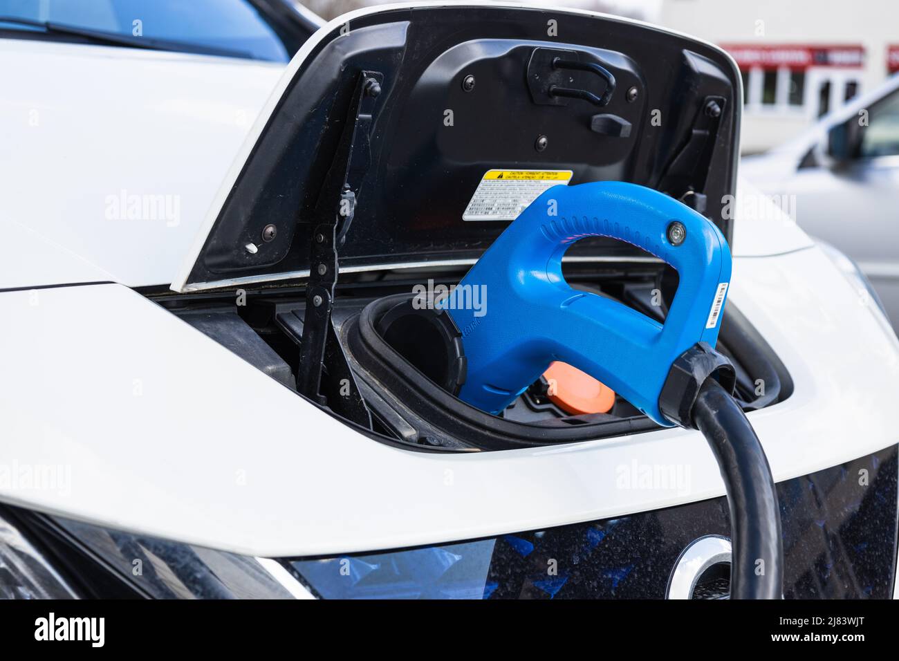 Electric vehicle or EV car with the power cable supply plugged in Stock ...