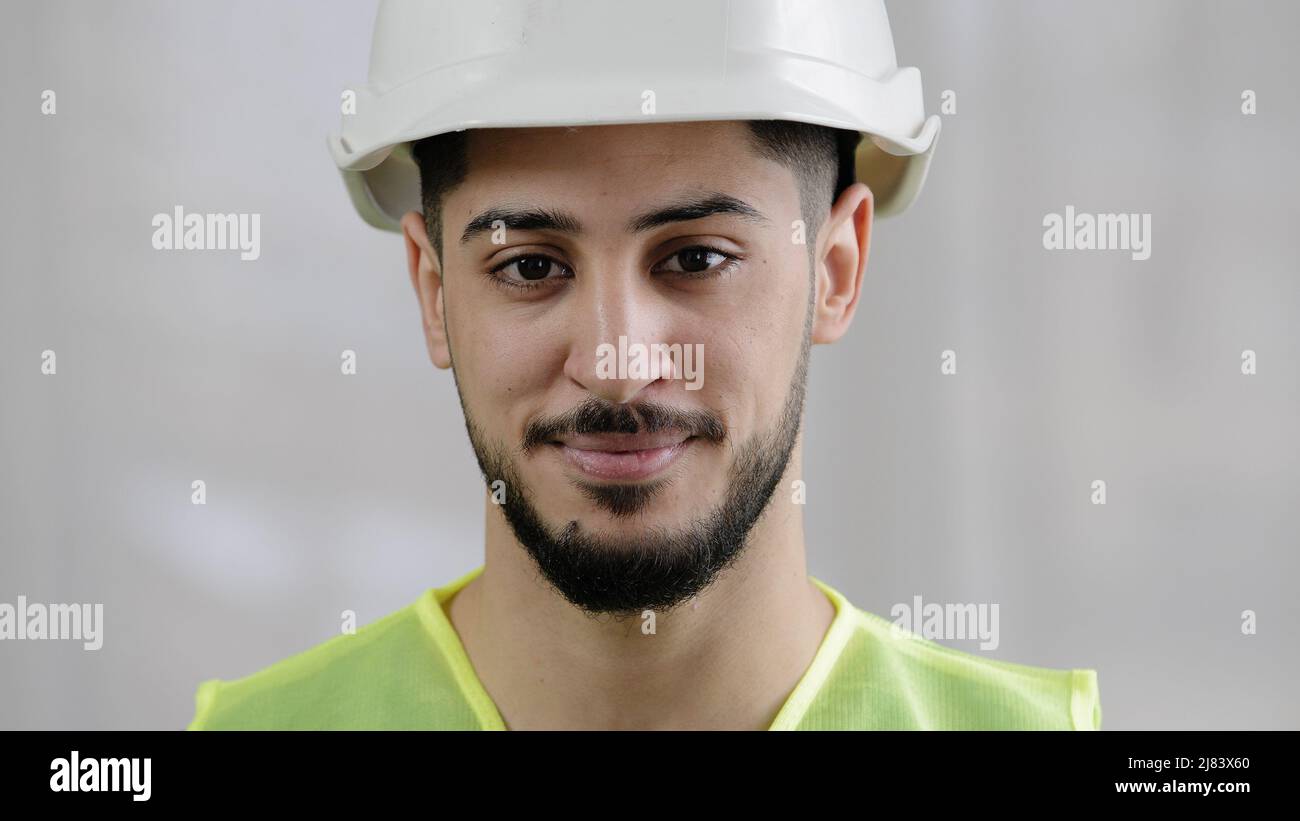 Front view male professional inspector arab man builder mechanic engineer worker wear special uniform hard hat smiling hispanic foreman posing for Stock Photo