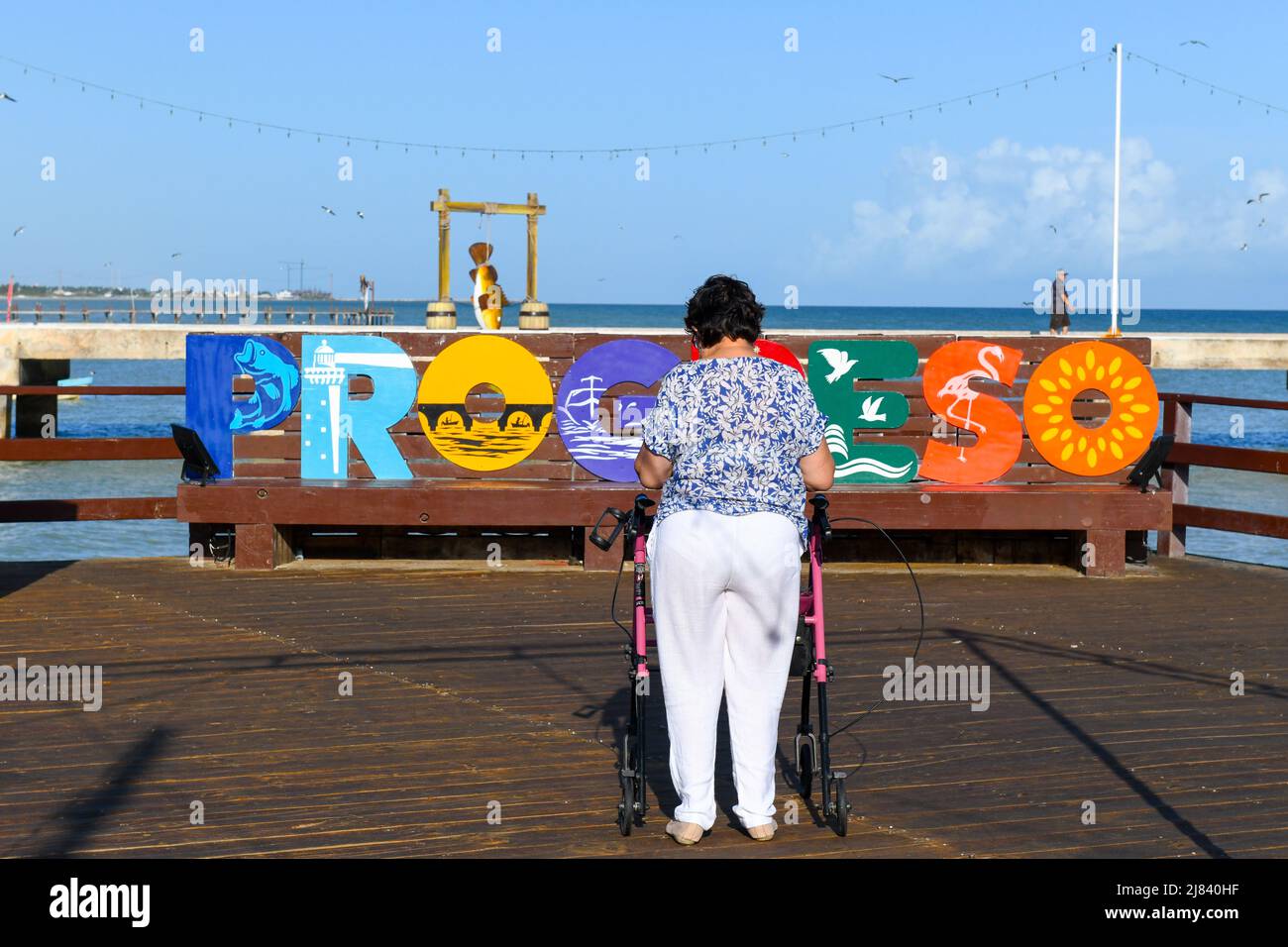 Woman walks on the Boardwalk with the help of a walker , Progreso ,Yucatan, Mexico Stock Photo