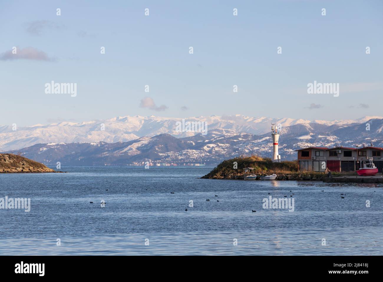 Arakli, Trabzon, Turkey. Coastal view with beacon tower at the entrance to small Fishing harbor. Black Sea coast on a sunny morning Stock Photo