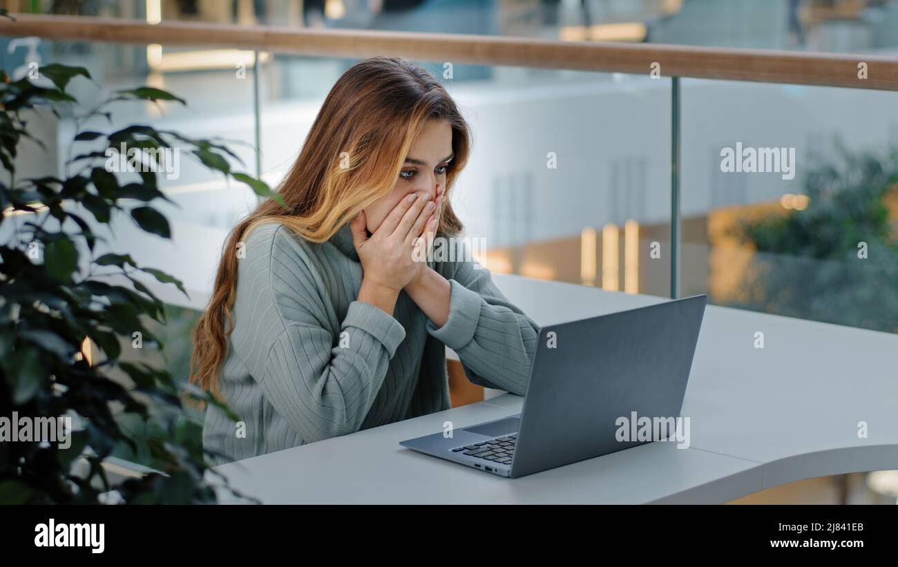 Caucasian stressful business woman with laptop frelancer girl frustrated shocked reading bad online news email failed test exam results reads Stock Photo