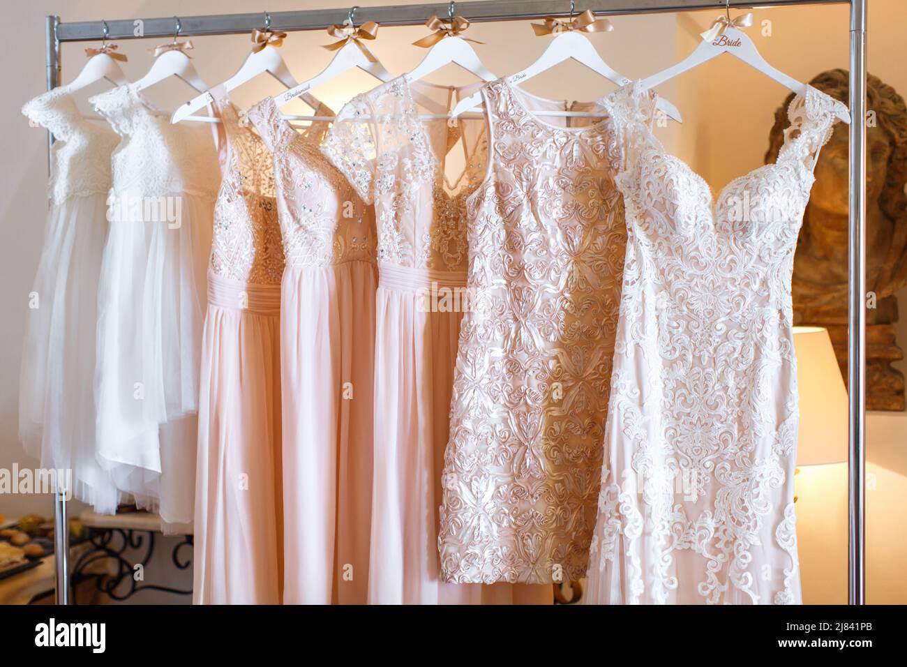 Wedding and bridesmaids dresses hanging on a metal hanger Stock Photo ...