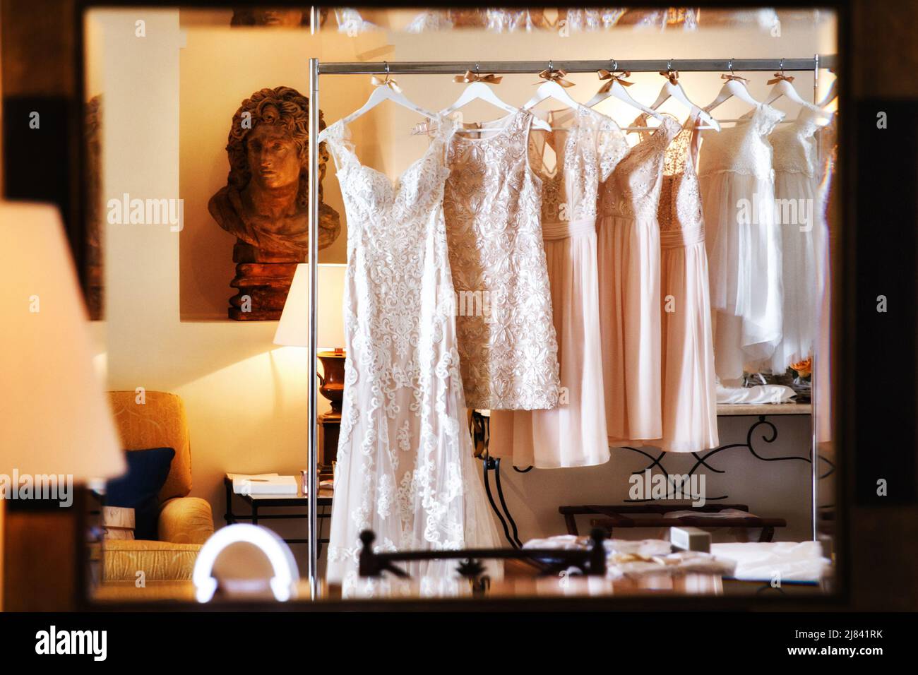 Wedding and bridesmaids dresses hanging on a metal hanger Stock Photo ...