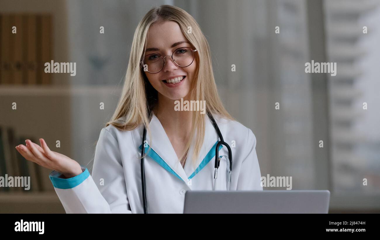 Webcam view caucasian female nurse in glasses sit indoor clinic hospital web doctor woman consult advise patient consultation by video call Stock Photo