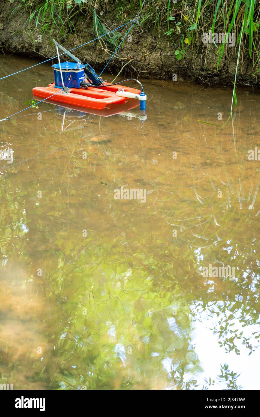 An Acoustic Doppler Current Profiler (ADCP) set up on a small stream for a river science project Stock Photo