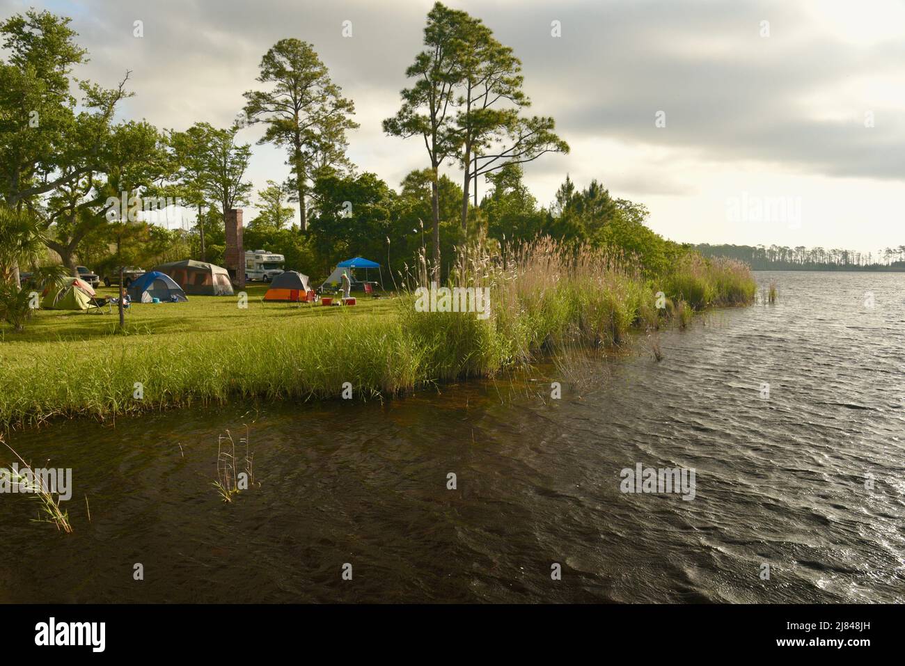 Cabin rental units and camping, water edge, along Lake Shelby in Gulf State Park, along coastline community of Gulf Shores, Alabama, USA Stock Photo