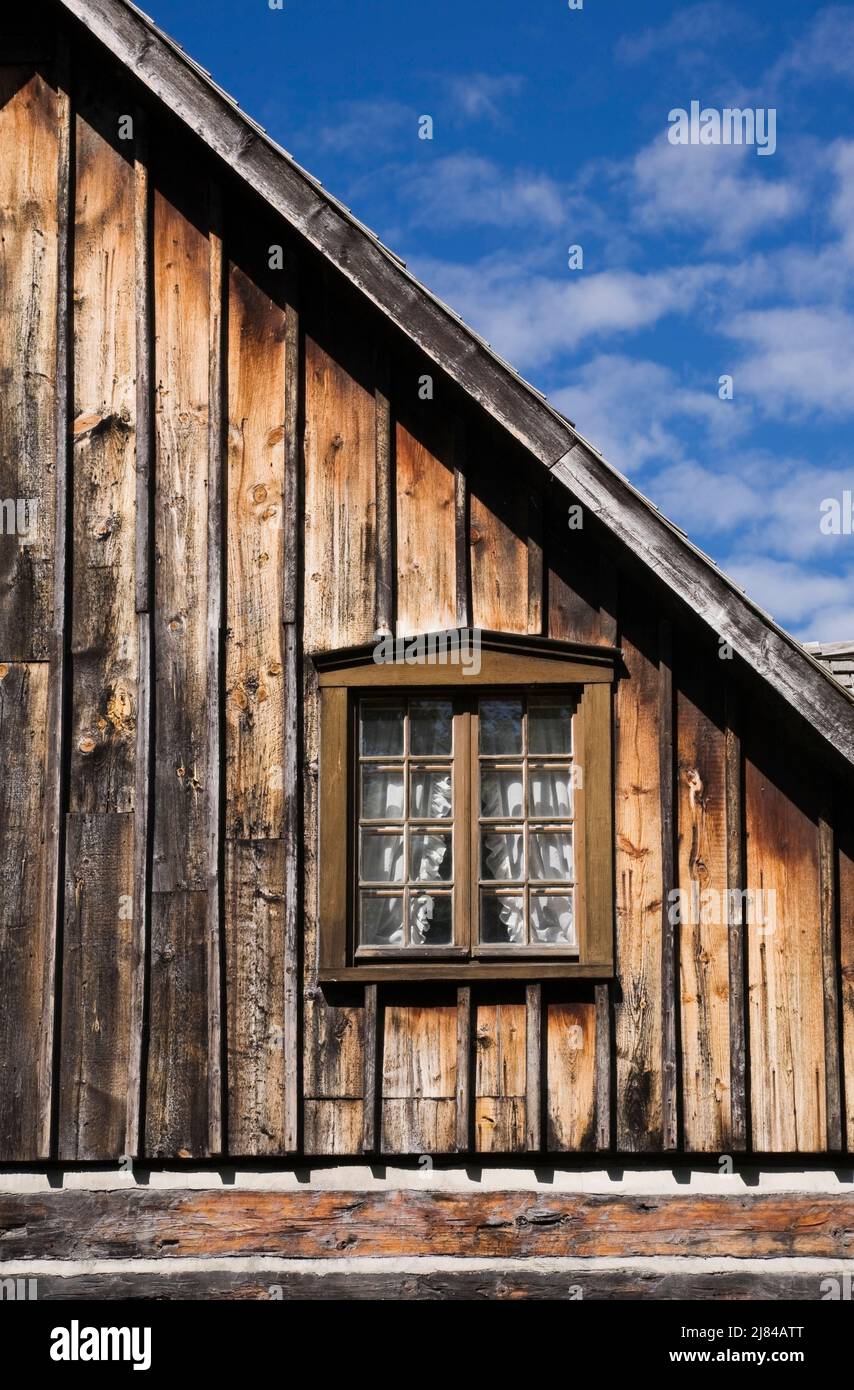 Brown stained wooden glass pane window on wall of old 1800s Canadiana