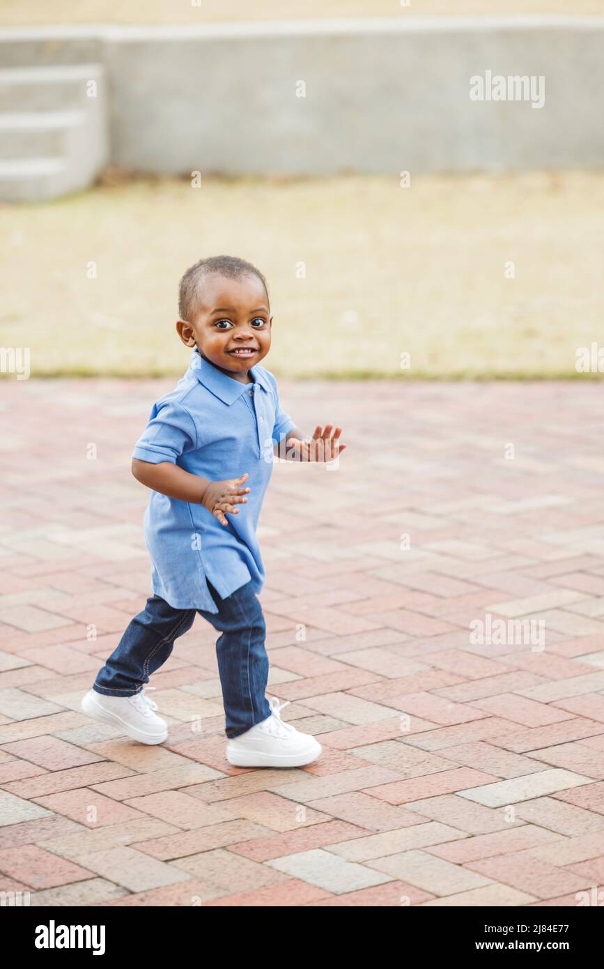 A cute one year old toddler walking outside Stock Photo