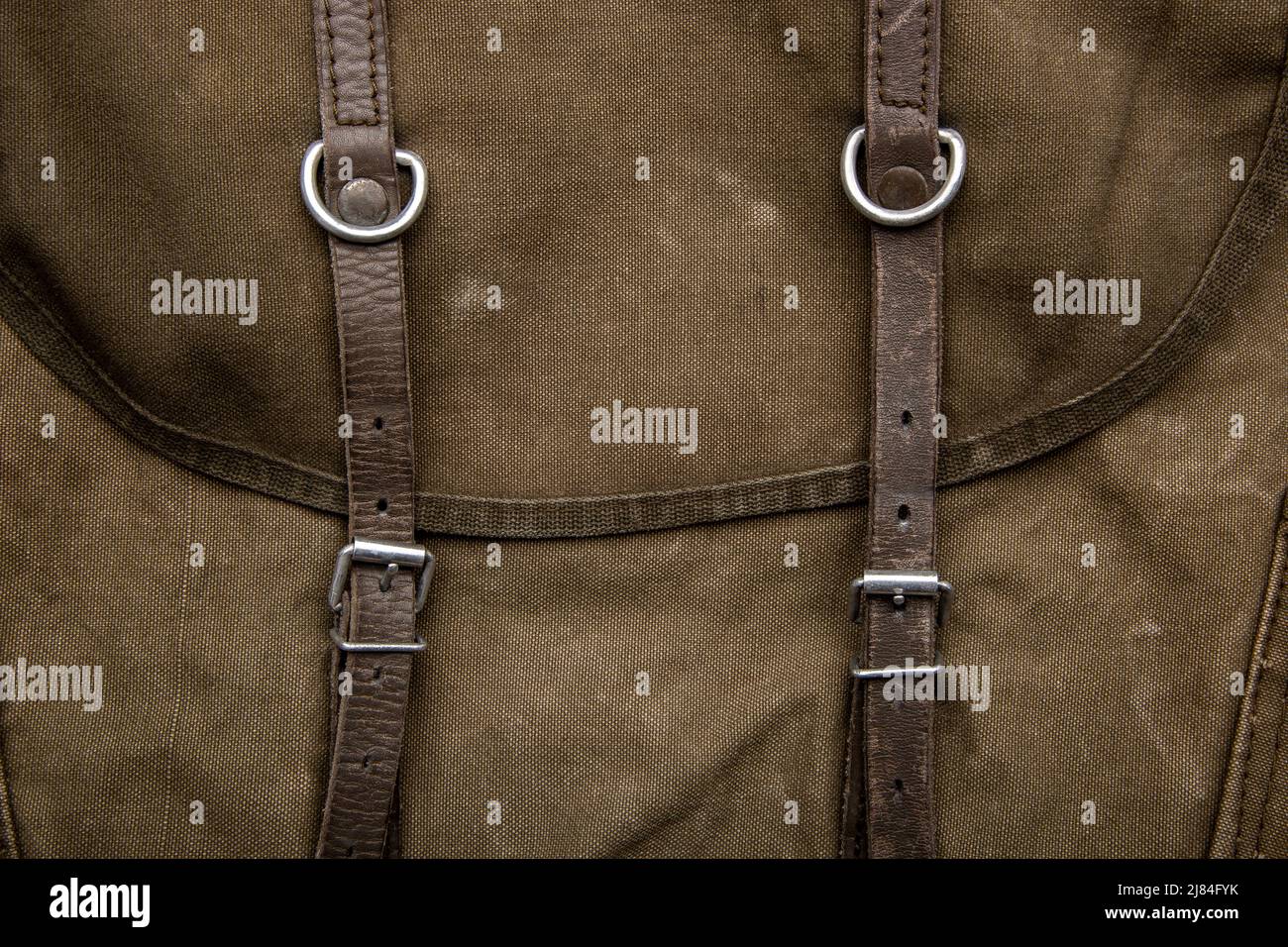 Closeup texture of a canvas fabric backpack. Leather straps and metal