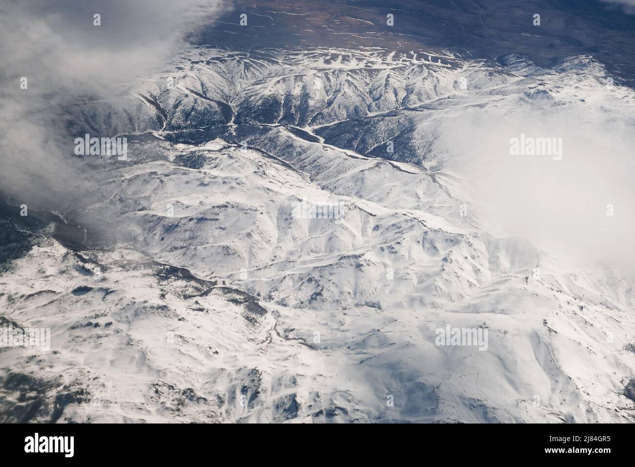 Aerial view of snowy mountains with clouds Stock Photo - Alamy