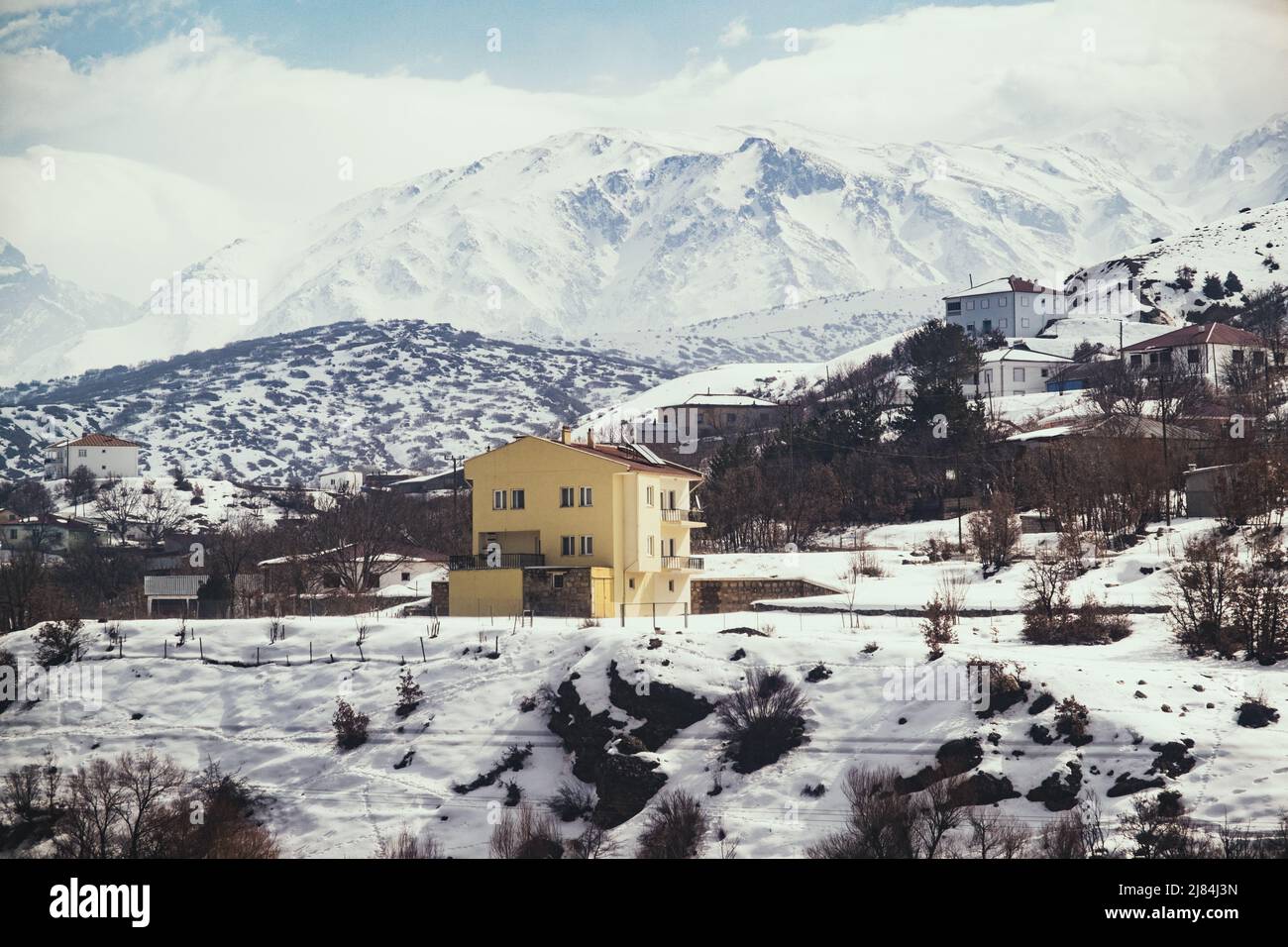 Erzincan, Turkey - February 22, 2022: Some village buildings in winter with snow and snowy mountains in Erzincan Turkey Stock Photo