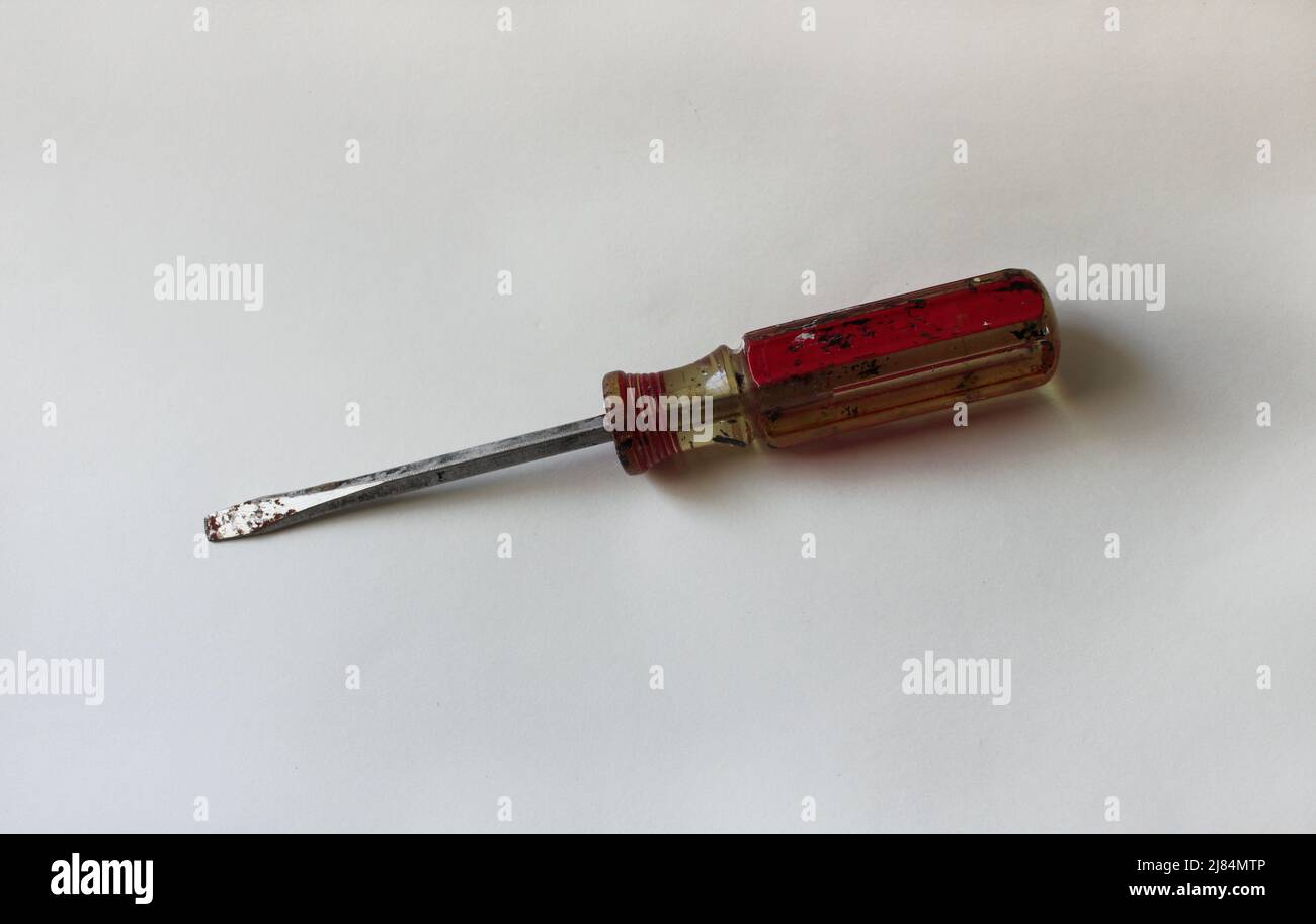 An Old Red and Yellow Flathead Screwdriver on a White Background Stock Photo