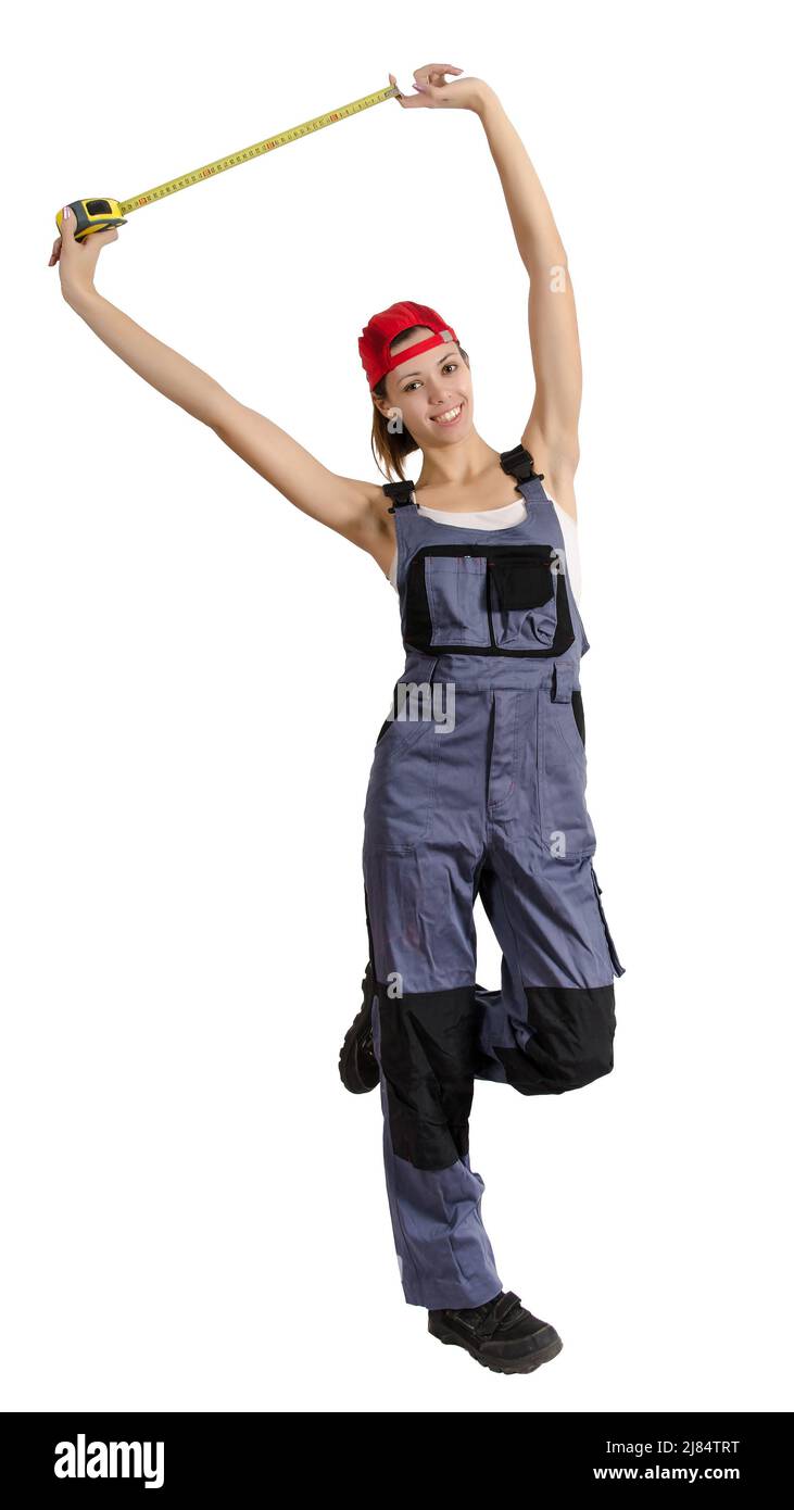 Young girl in overalls with a construction tape measure in hand. Isolated on white Stock Photo