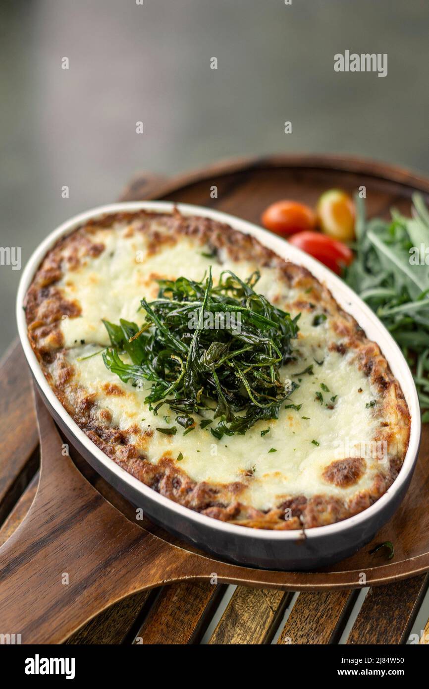 fresh beef lasagna in traditional oven dish on table in rome italy restaurant Stock Photo