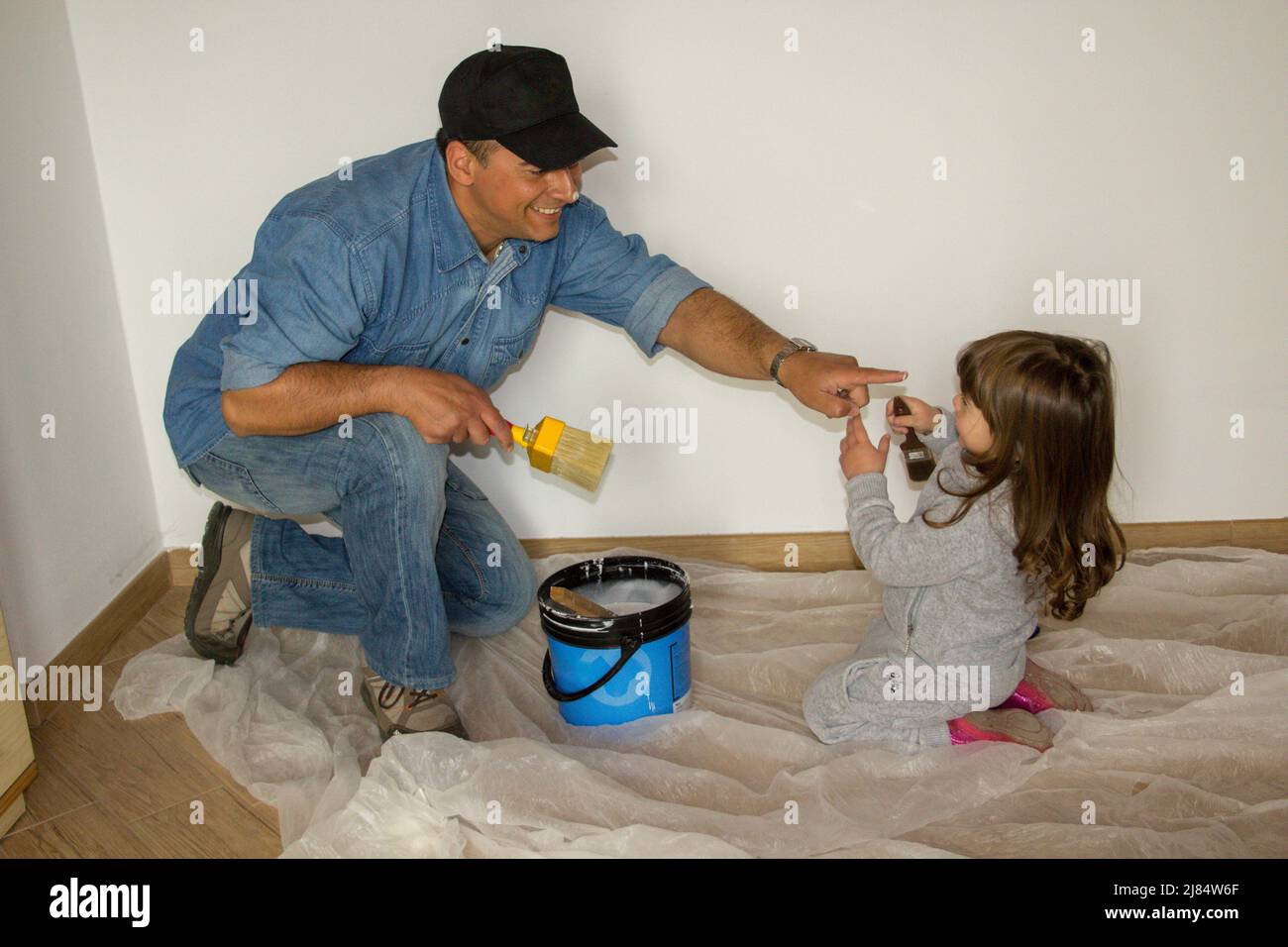 Photo of a father and daughter playing together while painting the ...