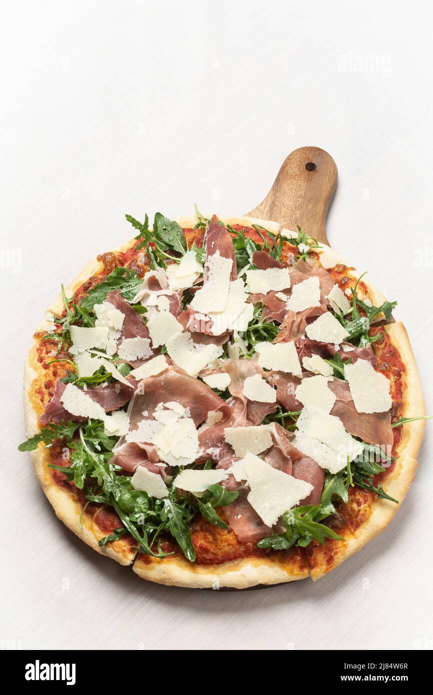 parma ham, rocket leaves and parmesan cheese gourmet pizza on white