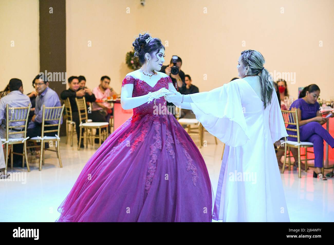Mexican mother and daughter dance during the celebration of the daughter's Quinceañera (15th birthday) for girls. This special occasion is celebrated by girls throughout Latin America / Campeche, Mexico Stock Photo