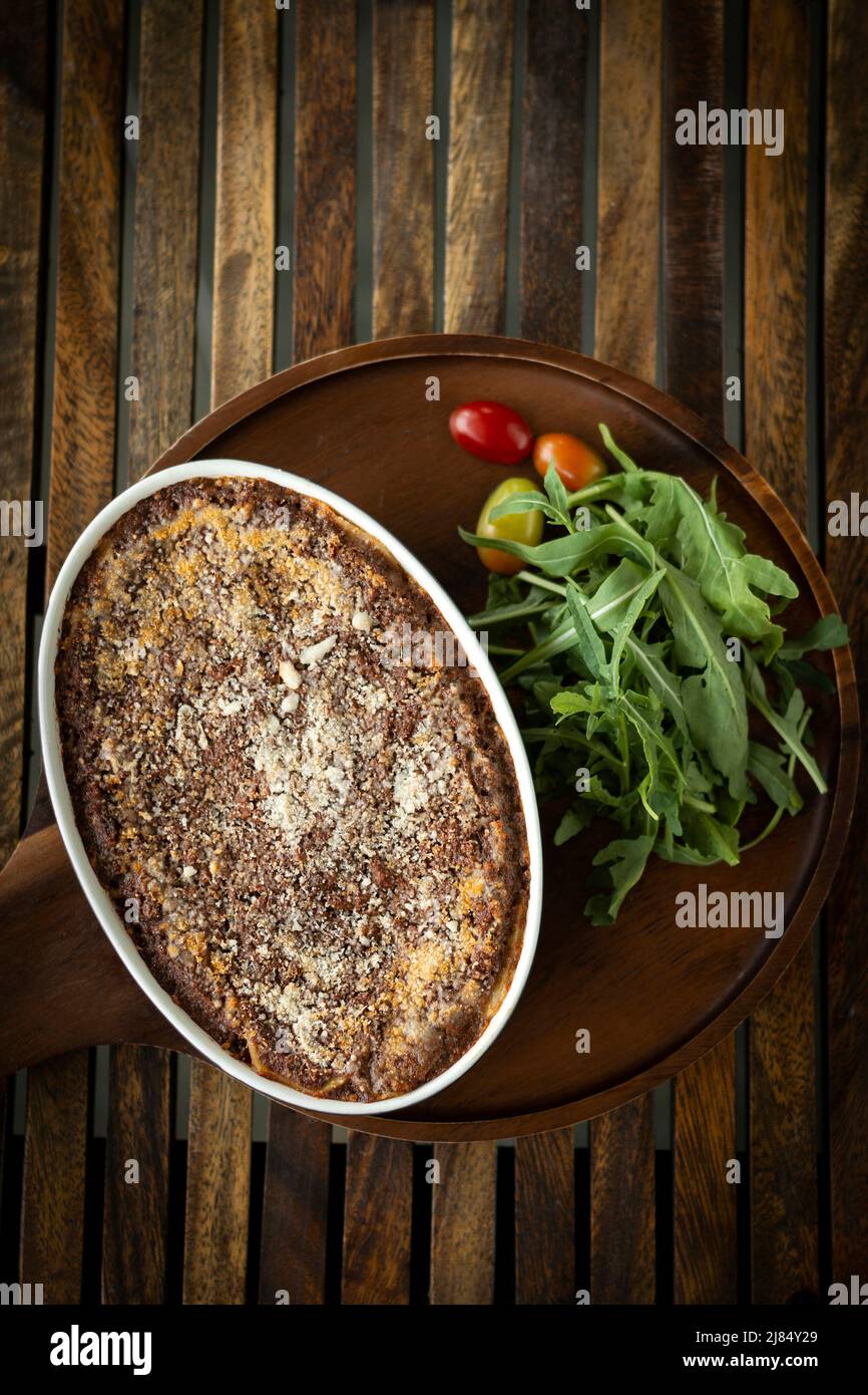 fresh beef lasagna in traditional oven dish on table in rome italy restaurant Stock Photo