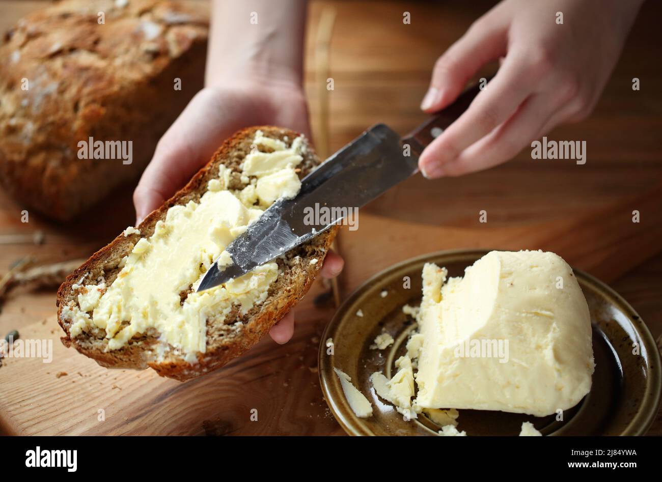 Hands spreading butter on bread Stock Photo Alamy