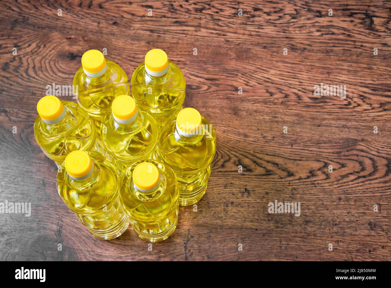 Top view of plastic bottles with sunflower vegetable oil on a wooden