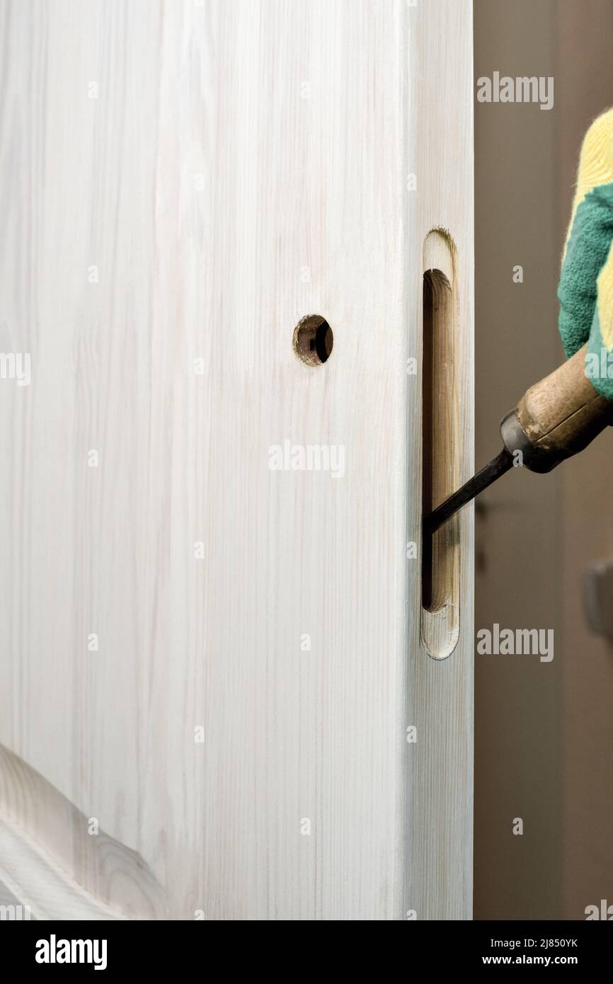 Installing a lock on a wooden door. Cutting a hole for a door lock with