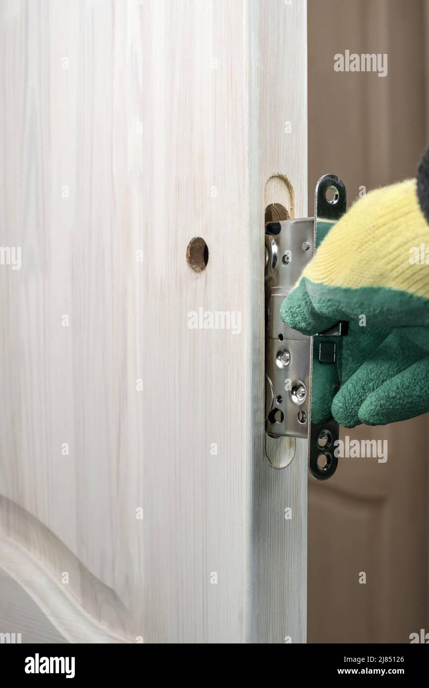 Installing a lock on a wooden door. Door lock repair and replacement