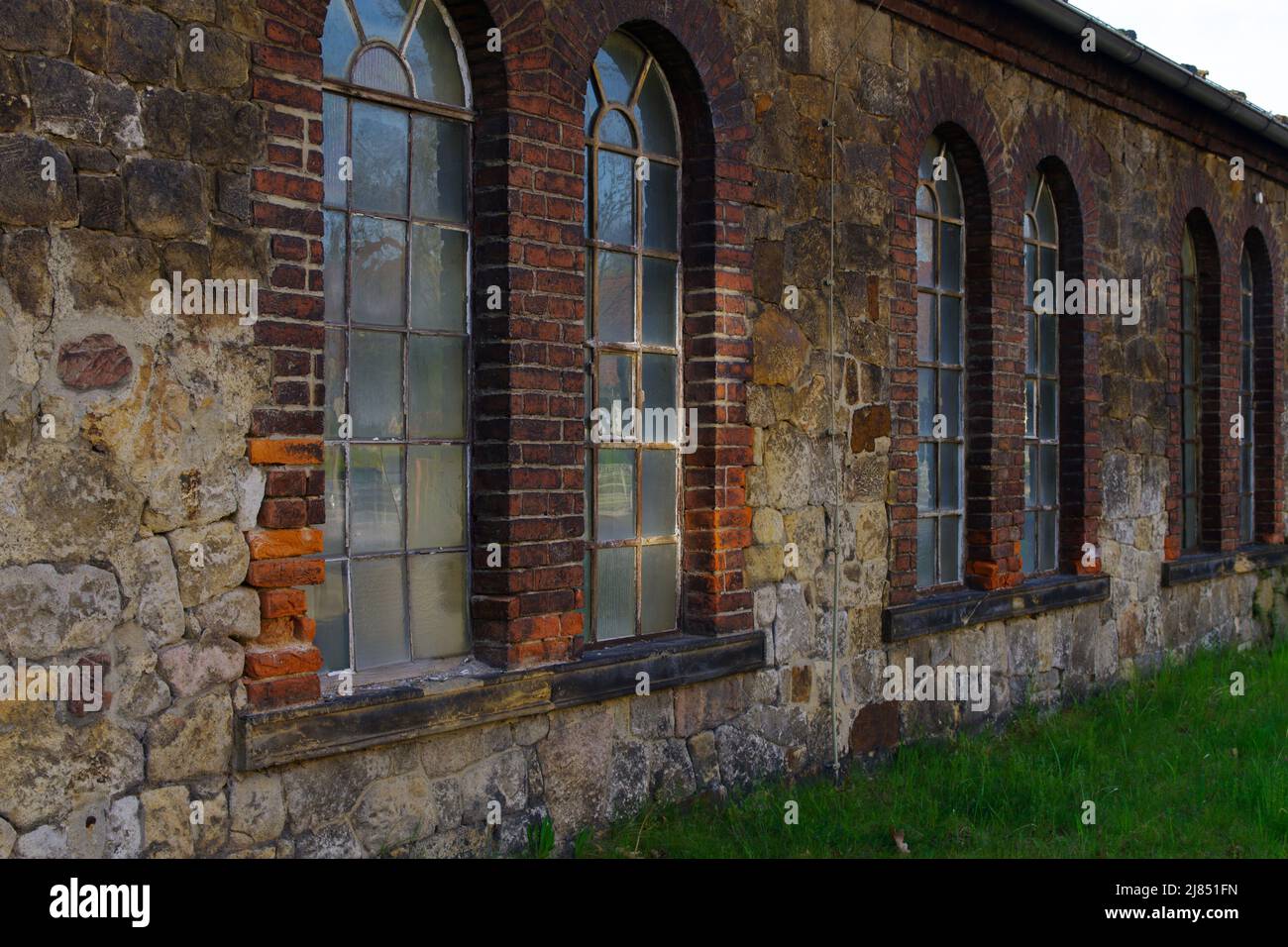 windows and red brick facade of old abandoned factory building in Germany Stock Photo