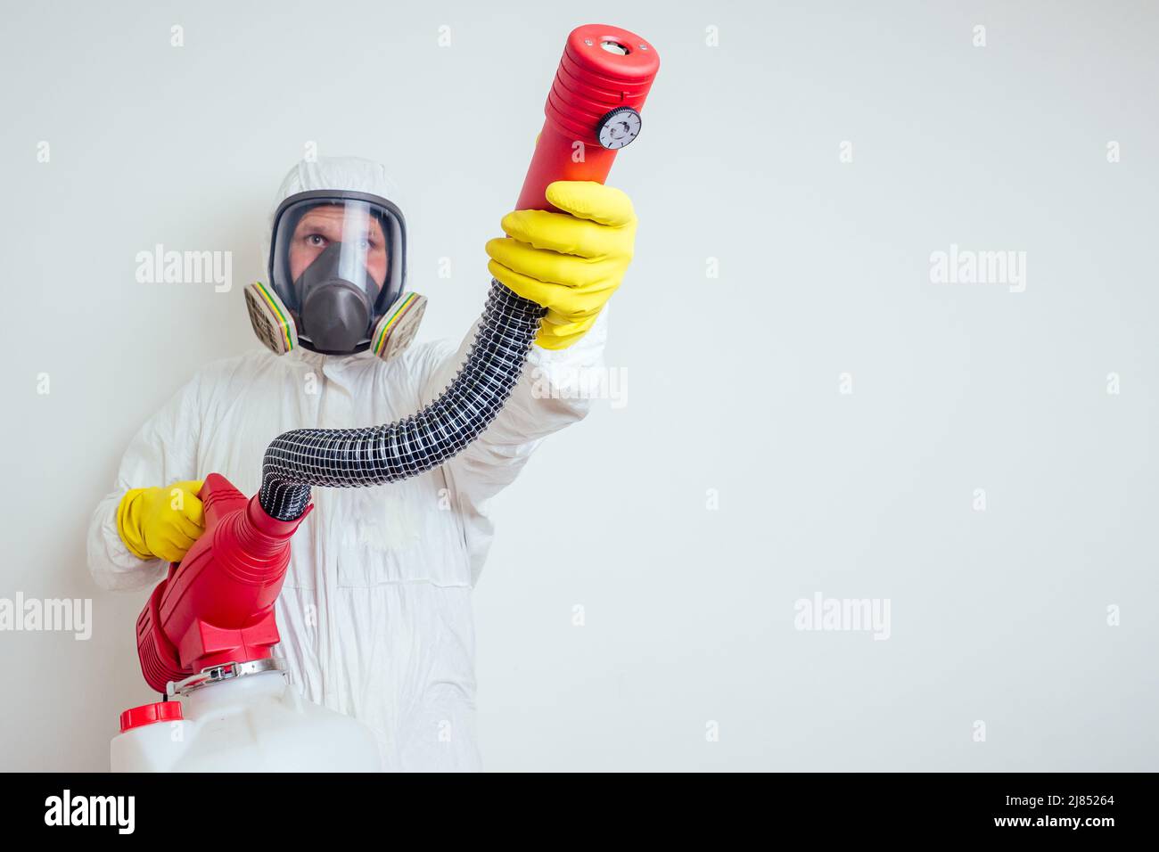 pest control worker spraying pesticides with sprayer in apartment copy