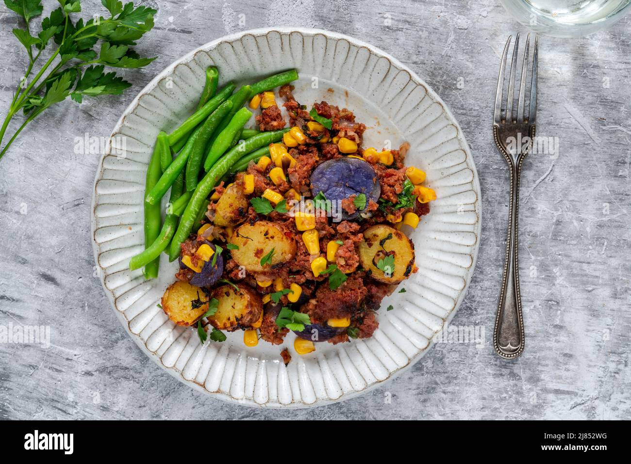 Corned beef, sweetcorn and potato hash with green beans Stock Photo Alamy