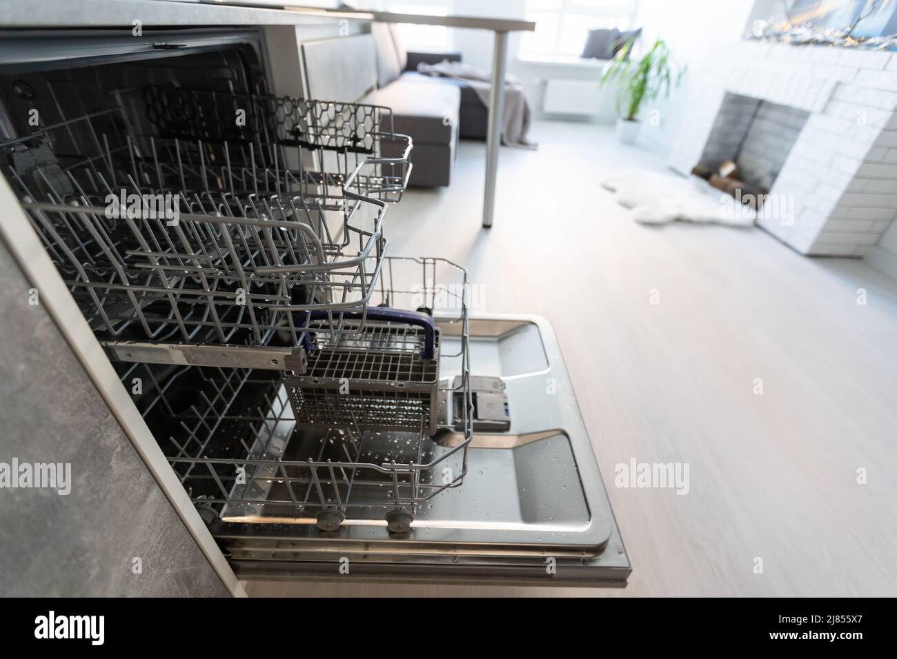 Modern kitchen with empty Builtin dishwasher with opened door