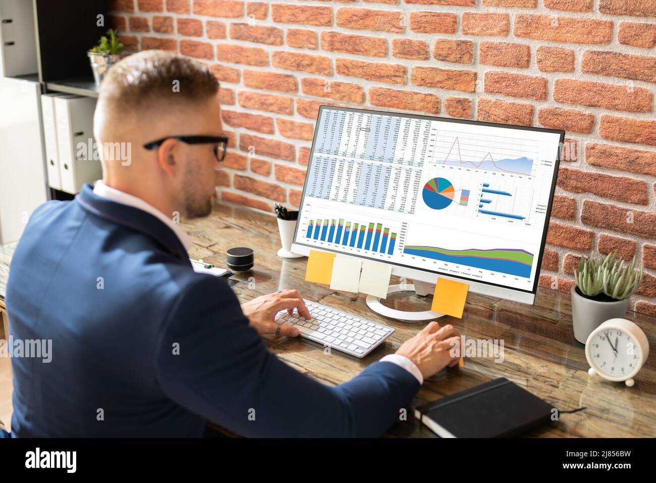 Business Data Analyst Using Desktop Computer. Entrepreneurship Charts Stock Photo