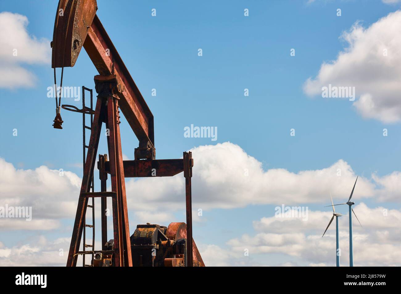 Oil pumping machine and windmills. Petroleum extraction. Resource Stock Photo