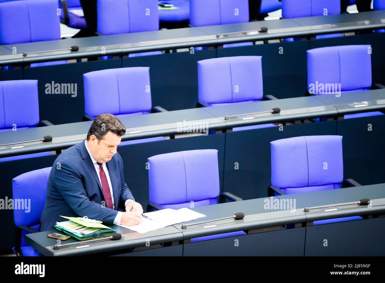 Berlin, Germany. 13th May, 2022. Hubertus Heil (SPD), Federal Minister of Labor and Social Affairs, sits on the plenum of the German Bundestag from the government bench. The agenda includes deliberations on the 2022 pension adjustment, the abolition of the ban on abortion advertising, the suspension of Hartz IV sanctions and the reduction of the energy tax on fuels. Credit: Christoph Soeder/dpa/Alamy Live News Stock Photo