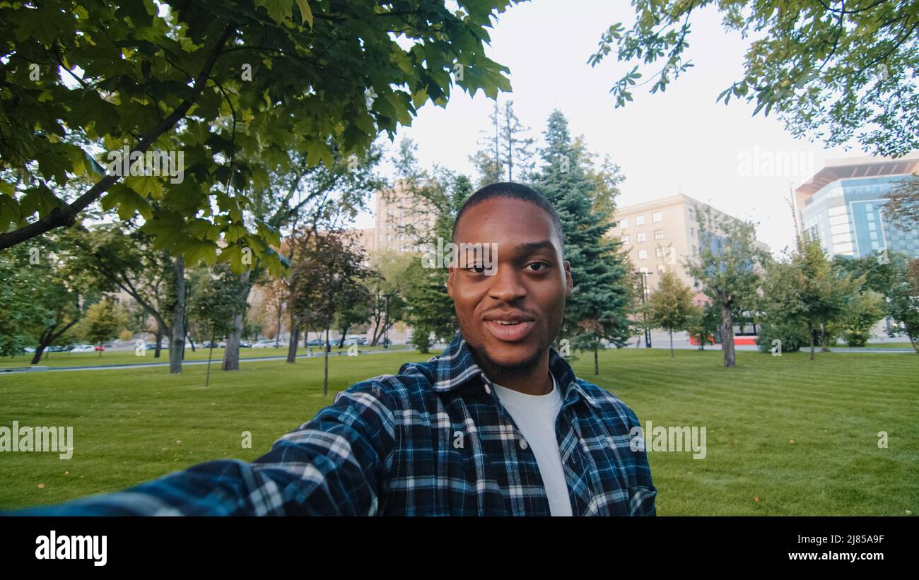 Web cam view happy cheerful african american man enthusiastic exited guy student teenager male holding camera selfie spinning rotating smiling Stock Photo