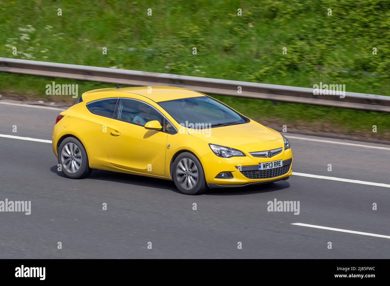 2015 yellow Vauxhall Astra GTC SRI CDTi 1956cc diesel 2dr hatchback; driving on the M61 Motorway, Manchester, UK Stock Photo